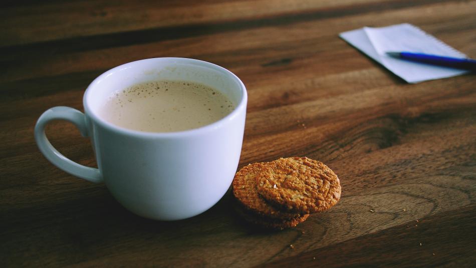 一杯奶茶一个饼干摄影图片